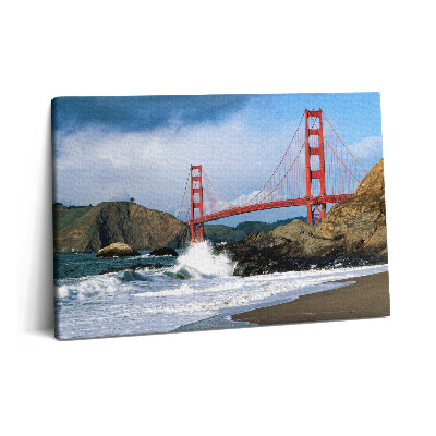 Obraz canvas 60x40 Fale na brzegu morza i czerwony most